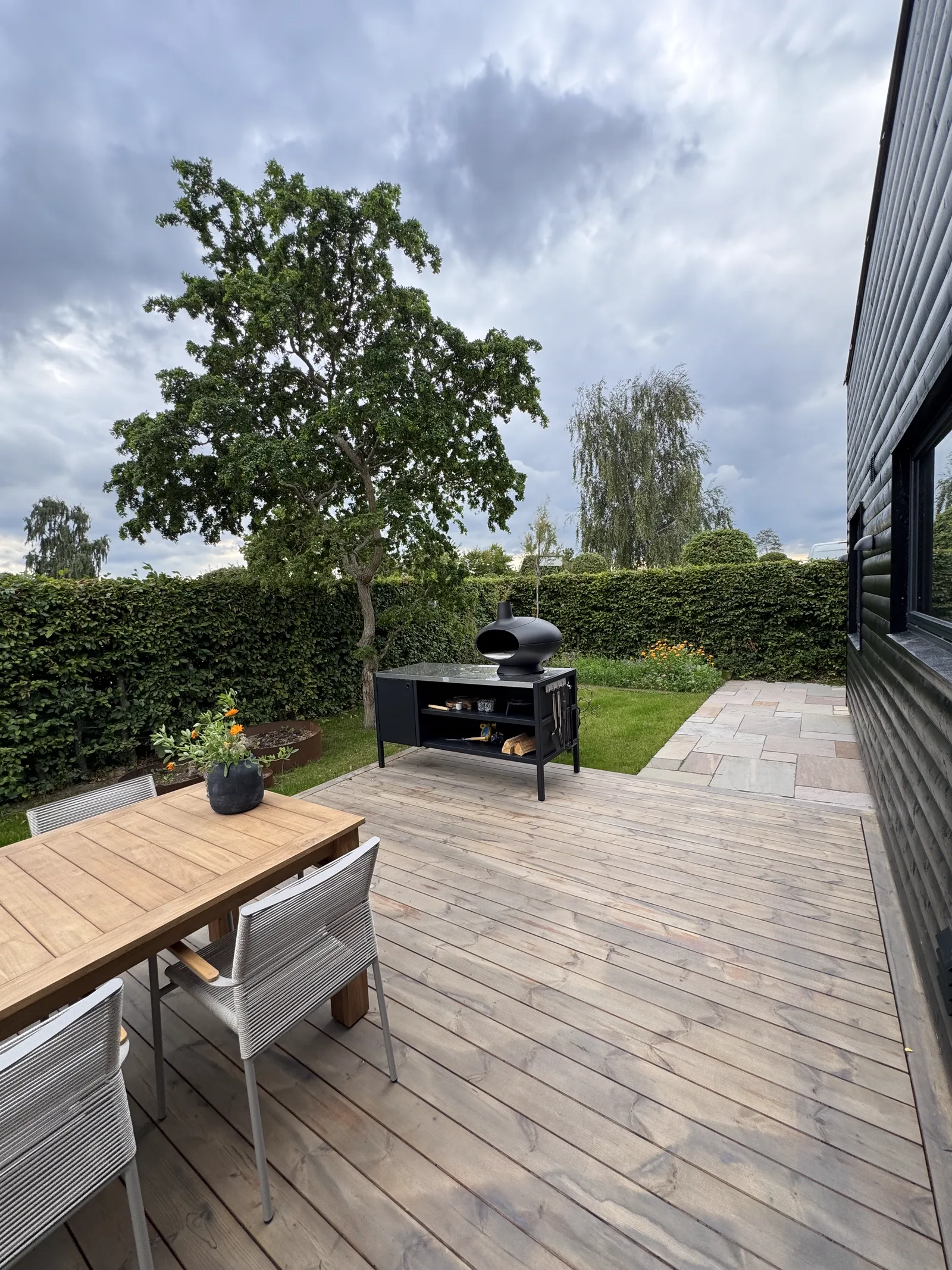 Kolonihavehus: udeareal med terrasse og haven omkring huset